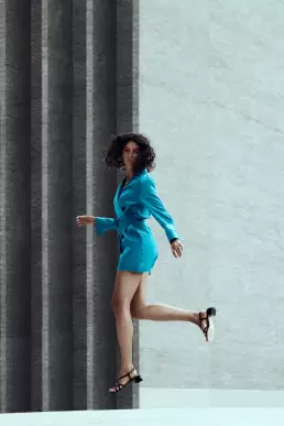 woman blue dress jump building